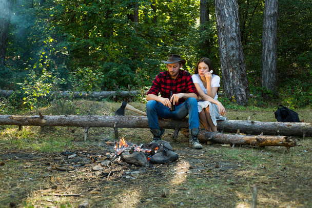 Couple in love having picnic in the country. Enjoying camping holiday in countryside. Couple camping concept. Young people enjoying picnic in park on summer day. Summer vacation forest. - Fotó, kép