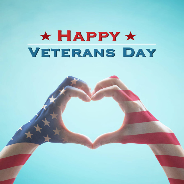 USA Happy veterans day with United Stated of America flag pattern on people's hands in heart shape on blue sky greeting announcement honoring all veterans who served American country  - Фото, изображение