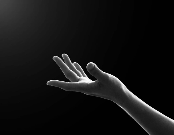 Ręka modlitwy modląca się o duchowe wsparcie, pomoc i pomoc humanitarną (ręka kobiety odizolowana na czarnym tle ze ścieżką wycinania) - Zdjęcie, obraz