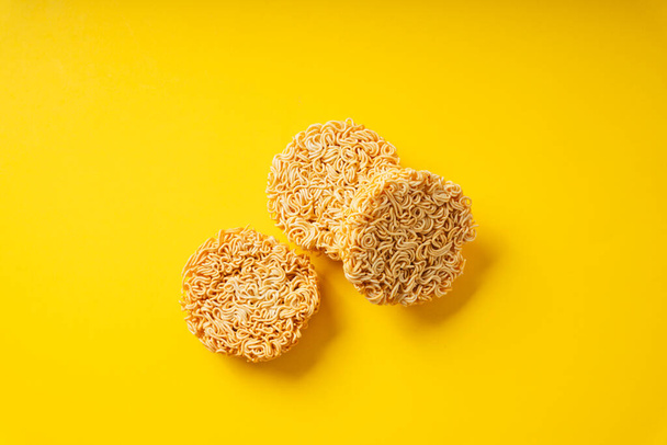 Group of circle shape instant noodle over yellow background. Top view. - Foto, afbeelding