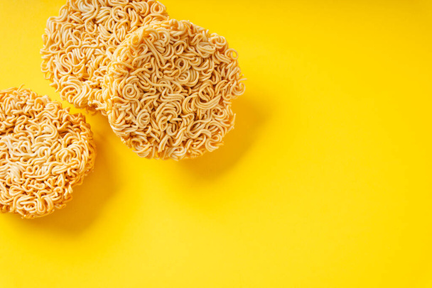 Group of circle shape instant noodle over yellow background. Top view. - Photo, Image