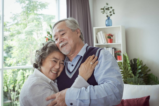 Szczęśliwa para starych starszych mężczyzn i kobiet przytulających się i zadowolonych z uśmiechu razem w domu, emerytury i opieki zdrowotnej stylu życia i koncepcji relacji kochanków - Zdjęcie, obraz