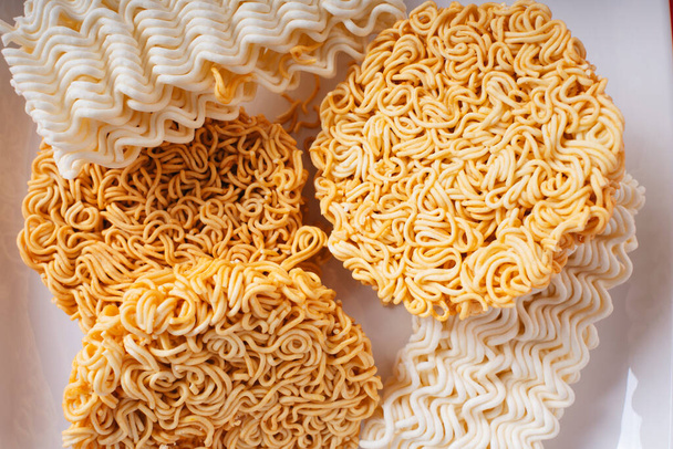 Top view - Many type of instant noodles on white plate over red background. - Photo, Image