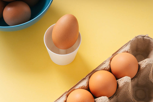 Organiczne jajko z kurczaka w pudełku kartonowym i miseczce. - Zdjęcie, obraz
