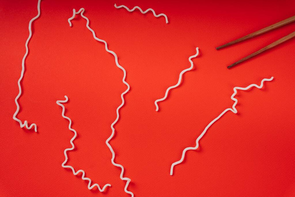 Υφή του στιγμιαίου noodle πάνω από το κόκκινο φόντο. Απομονωθείτε με κόκκινο. Σύνθεση γραμμής. - Φωτογραφία, εικόνα