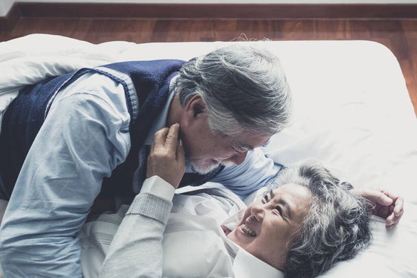 w podeszłym wieku para biały piękny senior mężczyzna i kobieta spać na łóżku i uśmiecha się w sypialni, emerytury opieki zdrowotnej z miłości styl życia koncepcja - Zdjęcie, obraz