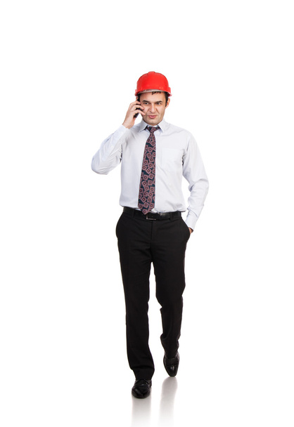 Man engineer in a red helmet talking on the phone - Foto, Imagem