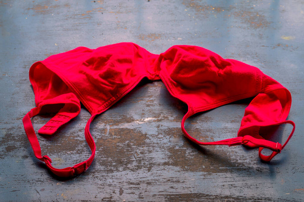 Red bra on rustic metallic floor. Romantic passion female lingerie. Sexy fashion background. Still life. - Foto, afbeelding