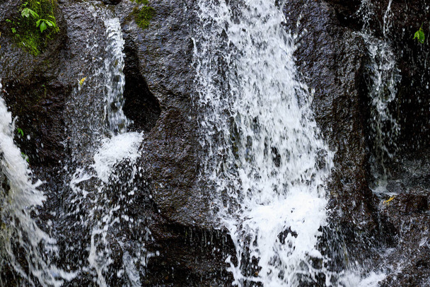 Feche a cascata. Fluxo dinâmico de água. Fundo aquático. Energia da água. Conceito de natureza e ambiente. Cachoeira Pucak Manik Bali, Indonésia
 - Foto, Imagem