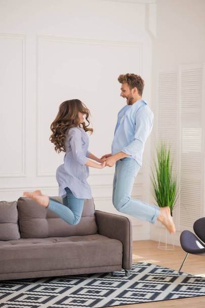 Young couple in denim jumping and holding hands - Photo, Image