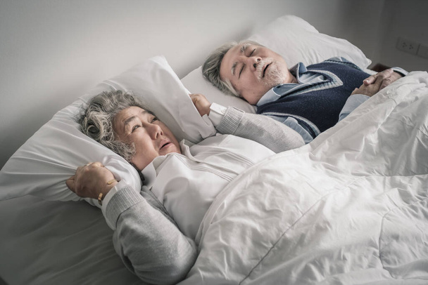 couple âgé caucasien senior femme et homme dorment sur le lit et ronflent dans la couverture blanche dans la chambre à coucher, soins de santé à la retraite avec amour concept de style de vie - Photo, image
