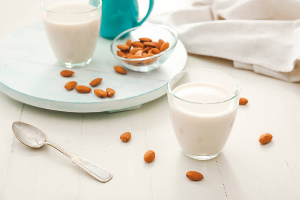 Copo de leite de amêndoa saboroso na mesa branca
 - Foto, Imagem
