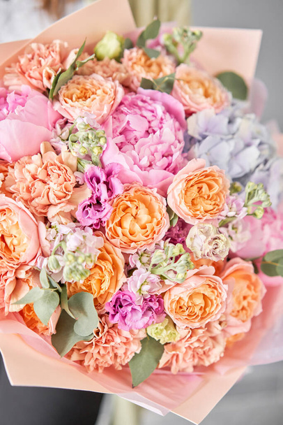 Roze pioenrozen en hortensia. Mooi boeket van gemengde bloemen in de hand van de vrouw. Bloemenwinkel concept. Mooi, fris boeket. Bloemen levering. - Foto, afbeelding