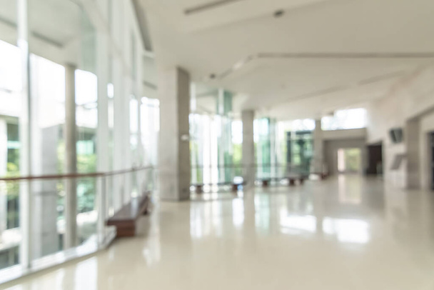 Hotel or office building lobby blur background interior view toward reception hall, modern luxury white room space with blurry corridor and building glass wall window - Photo, Image