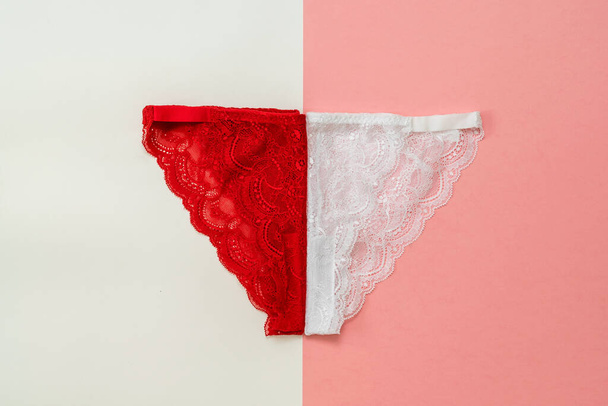 Červené a bílé dámské spodní prádlo na červenobílém pozadí. Spodní prádlo. Pohled shora.. - Fotografie, Obrázek