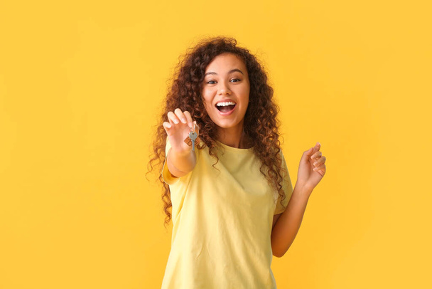 Happy young woman with key on color background - Photo, Image