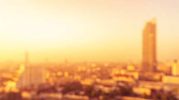 夏の太陽が都市の屋上ビューの背景都市景観オフィスビルの風景ぼやけた都市暖かい明るい熱波ライト黄金の時間のスカイライン熱波ボケ - 写真・画像