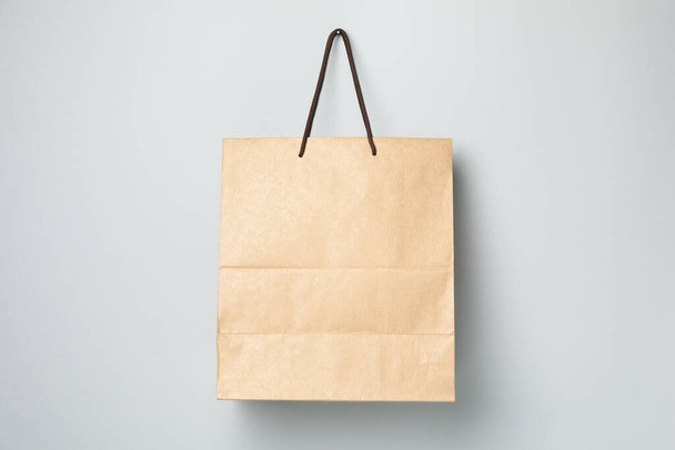 Empty paper bag on gray background, space for text. - Foto, Imagem