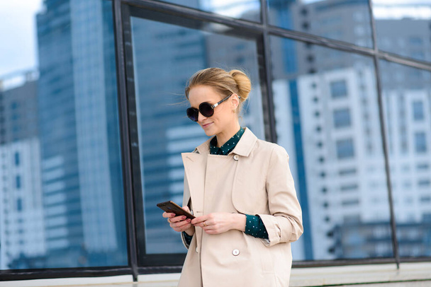 Retrato de una mujer de negocios usando un cuaderno, gafas, teléfono
 - Foto, Imagen