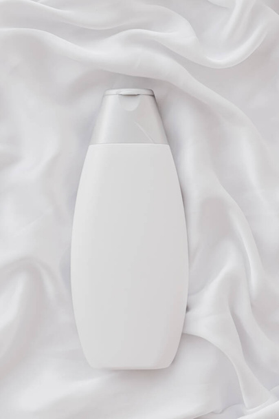 Üres címke kozmetikai tartály üveg mint termék mockup fehér selyem háttér - Fotó, kép
