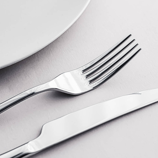 Placa vacía y cubiertos como juego de maquetas sobre fondo blanco, vajilla superior para la decoración de la mesa del chef y la marca del menú
 - Foto, imagen