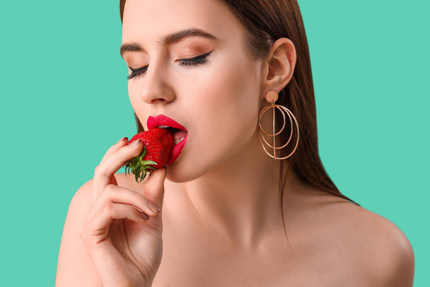 Sexy mujer joven con fresa en el fondo de color
 - Foto, Imagen