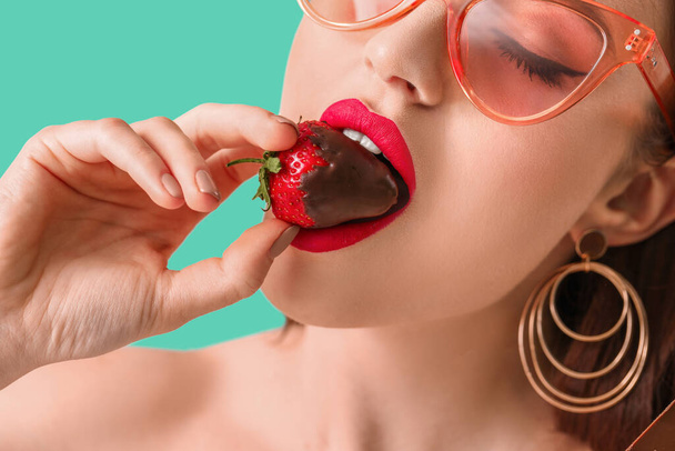 Sexy mujer joven con fresa en el fondo de color
 - Foto, imagen