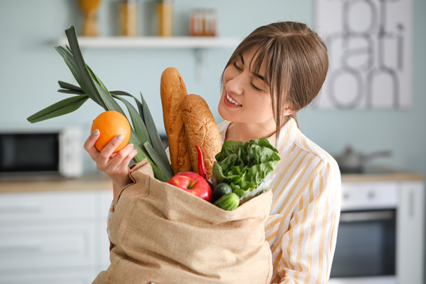 Young woman with fresh products from market at home - Photo, Image