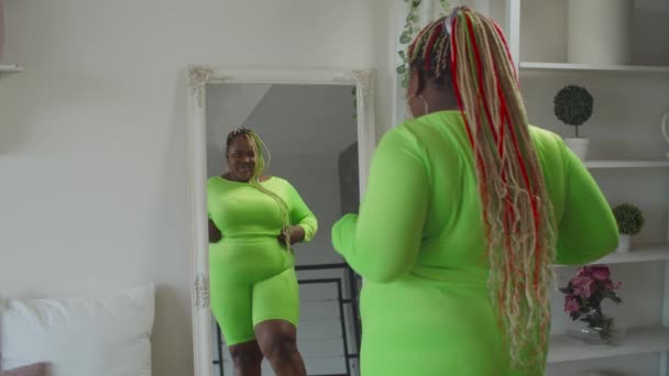 Happy plump black female admiring mirror reflection - Video