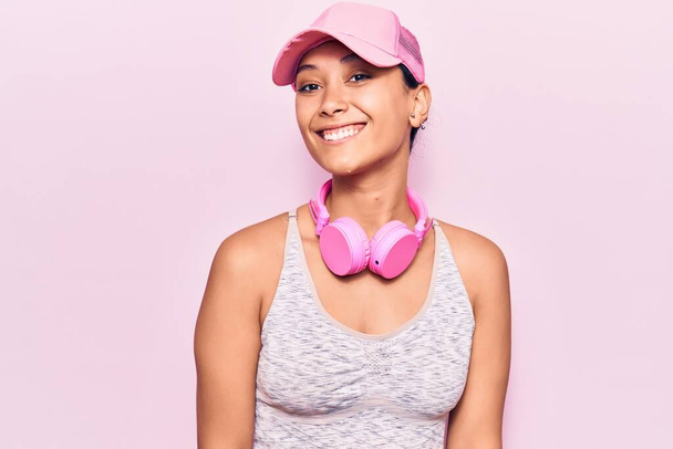 Jovem mulher ouvindo música usando fones de ouvido com um sorriso feliz e legal no rosto. pessoa de sorte
.  - Foto, Imagem