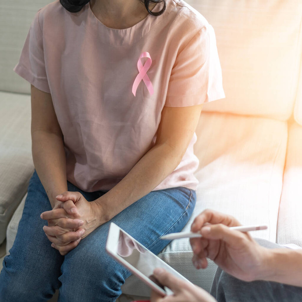 Рожева стрічка поінформованості про рак молочної залози про жінку, яка консультує пацієнта з лікарем, який діагностує обстеження на акушерську гінекологічну жіночу хворобу в медичній клініці або лікарні
 - Фото, зображення
