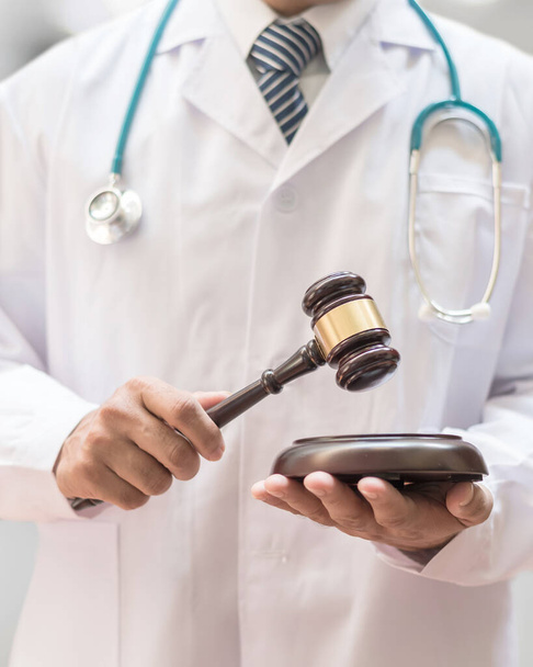 Dochodzenie sądowe medycyny sądowej lub praktyka lekarska - koncepcja sprawiedliwości o błędach w sztuce lekarskiej z młotkiem w rękach lekarza  - Zdjęcie, obraz