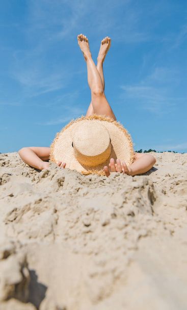 donna sdraiata sulla spiaggia di sabbia attraversando le gambe fino vacanza estiva - Foto, immagini