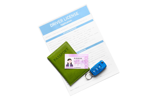 Prawo jazdy z formularzem zgłoszeniowym, kluczykiem samochodowym i paszportem na białym tle - Zdjęcie, obraz