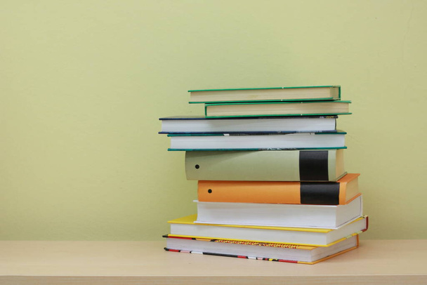 Stack of books on yellow background - 写真・画像