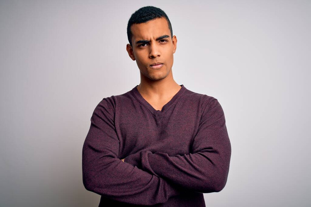 Young handsome african american man wearing casual sweater over white background skeptic and nervous, disapproving expression on face with crossed arms. Negative person. - Photo, Image