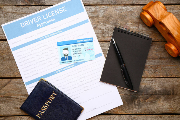 Ehliyet başvuru formu, pasaport ve tahta arka planda not defteri. - Fotoğraf, Görsel