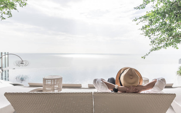 Pihenés nyaralás nyaralás üzletember vegye könnyedén boldogan pihen a strand széken medencénél medence mellett tengerparti üdülőhely szálloda tengerre vagy óceánra néző és nyári napos ég szabadban - Fotó, kép