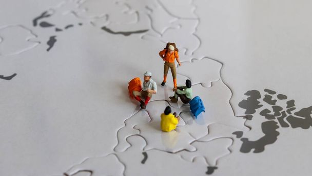 Miniatur-Touristen auf Weltkarte Rätsel. - Foto, Bild