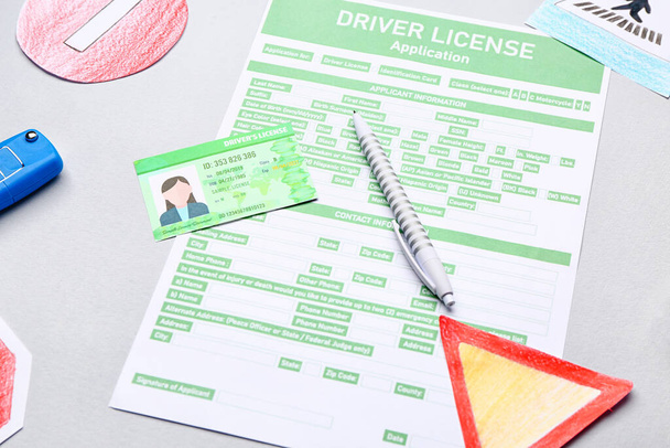 Řidičský průkaz s formulářem žádosti na šedém pozadí - Fotografie, Obrázek