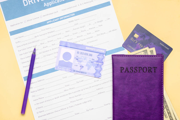 Άδεια οδήγησης με έντυπο αίτησης, διαβατήριο και χρήματα σε έγχρωμο φόντο - Φωτογραφία, εικόνα