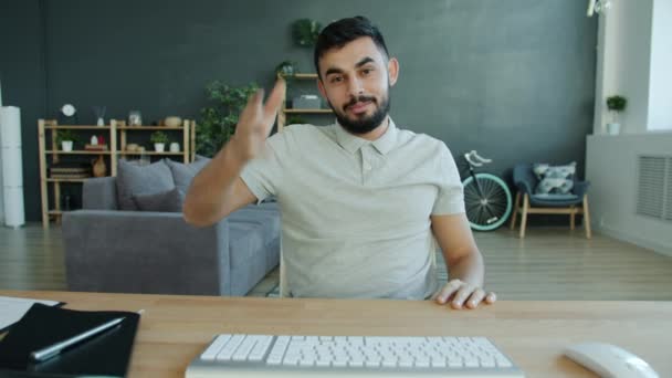 Cheerful Middle Eastern man making online video call looking at camera and talking at home - Felvétel, videó