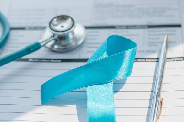 Cinta azul simbólica de la campaña de concienciación sobre el cáncer de próstata y la salud de los hombres en noviembre mes en forma de registro de salud de los pacientes con estetoscopio médico. - Foto, imagen