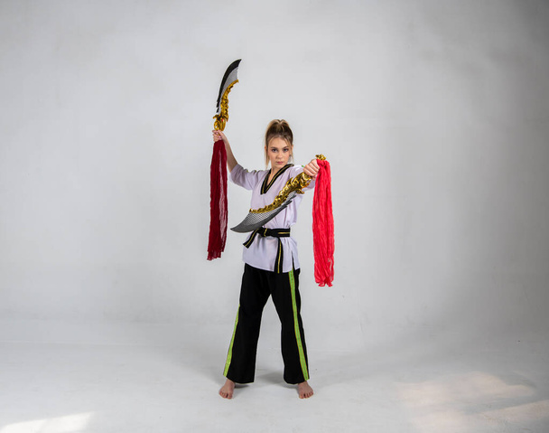 krásná dívka v černobílém kimonu a se zlatými meči - Fotografie, Obrázek
