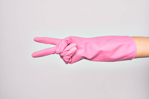 Ręka młodej kobiety rasy kaukaskiej w różowej rękawiczce na białym tle - Zdjęcie, obraz