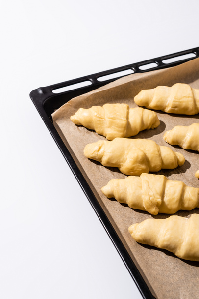 raw croissants on baking tray isolated on white background - Фото, изображение