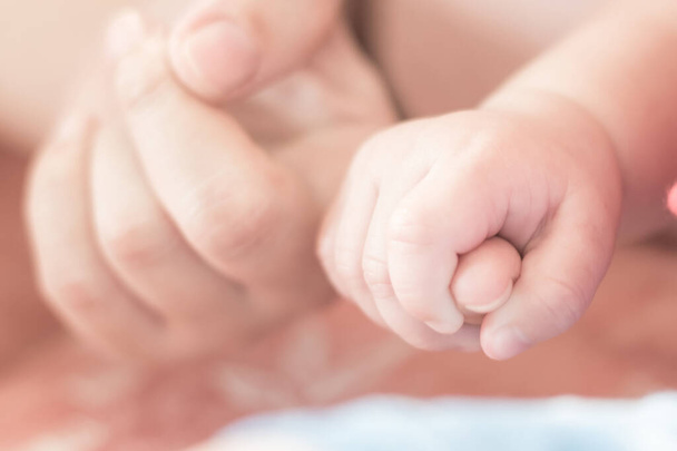 Yeni doğmuş bebek elleri, çocuk evlat edinme, çocuk bakımı ve yeni doğmuş bebek konsepti için annesinin parmak izini bulanık tutuyor.  - Fotoğraf, Görsel