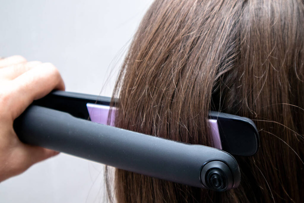 Hair iron straightening. Smooth hairstyle. Hairstyle Concept. High Resolution. - Photo, Image