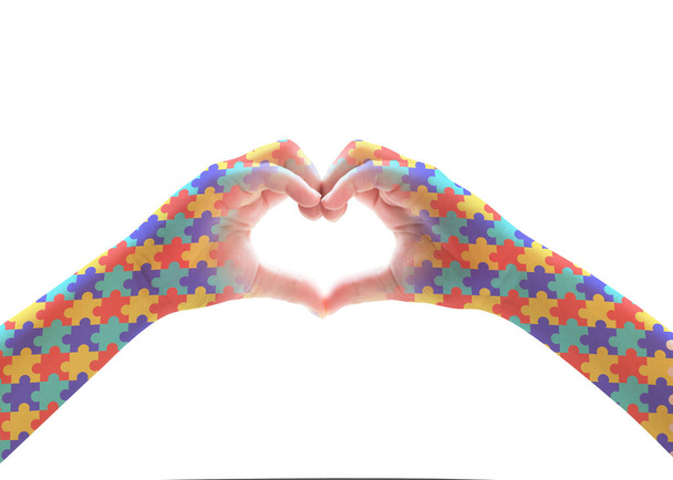 Autizmus Tudatosság Világnapja, mentális egészségügyi koncepció kirakós kirakós mintával a szív alakú gyerek kezén (elszigetelve a nyírási útvonallal) autista gyermek támogatására - Fotó, kép