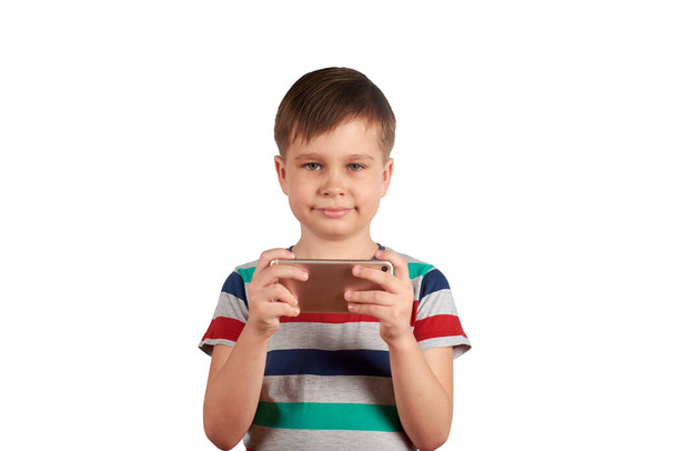 Little kid playing games on smartphone isolated over white background - Foto, Bild
